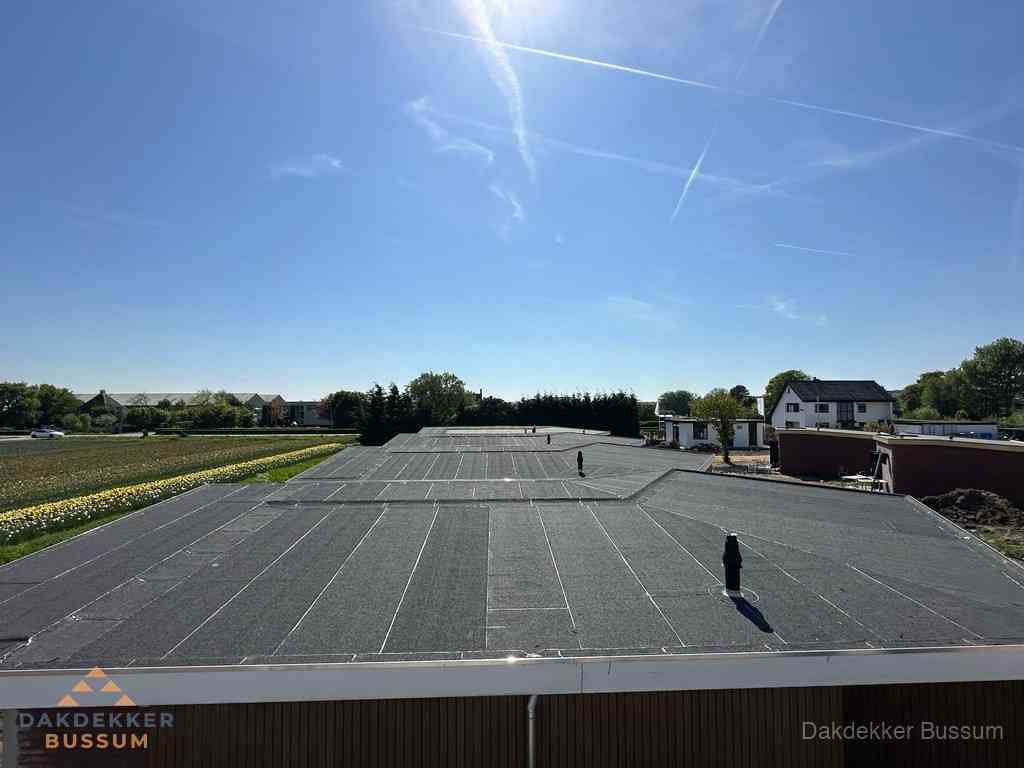 Groot plat dak met bitumen dakbedekking op bedrijfspand in Bussum Groot plat dak met bitumen dakbedekking op bedrijfspand in Bussum
