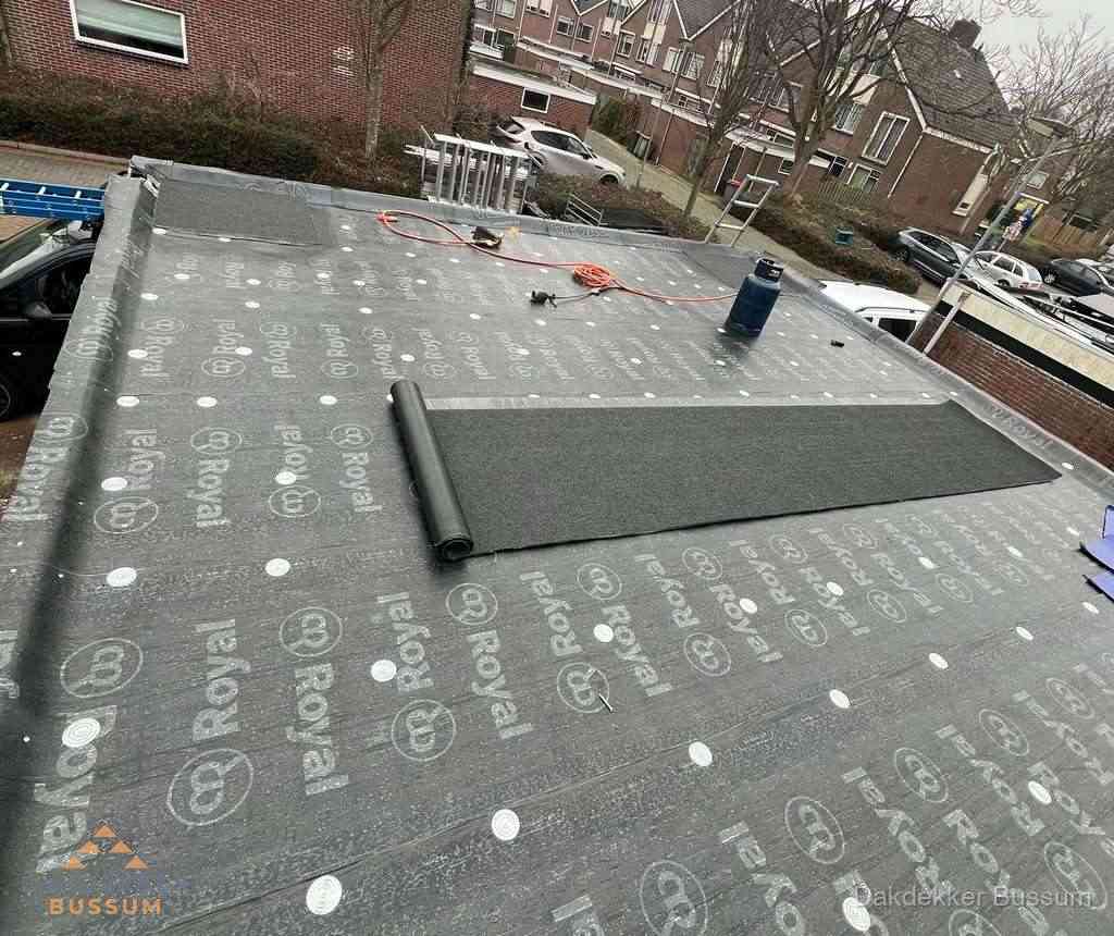 Dakdekker aan het werk met gasbrander op plat bitumen dak in Bussum Dakdekker aan het werk met gasbrander op plat bitumen dak in Bussum